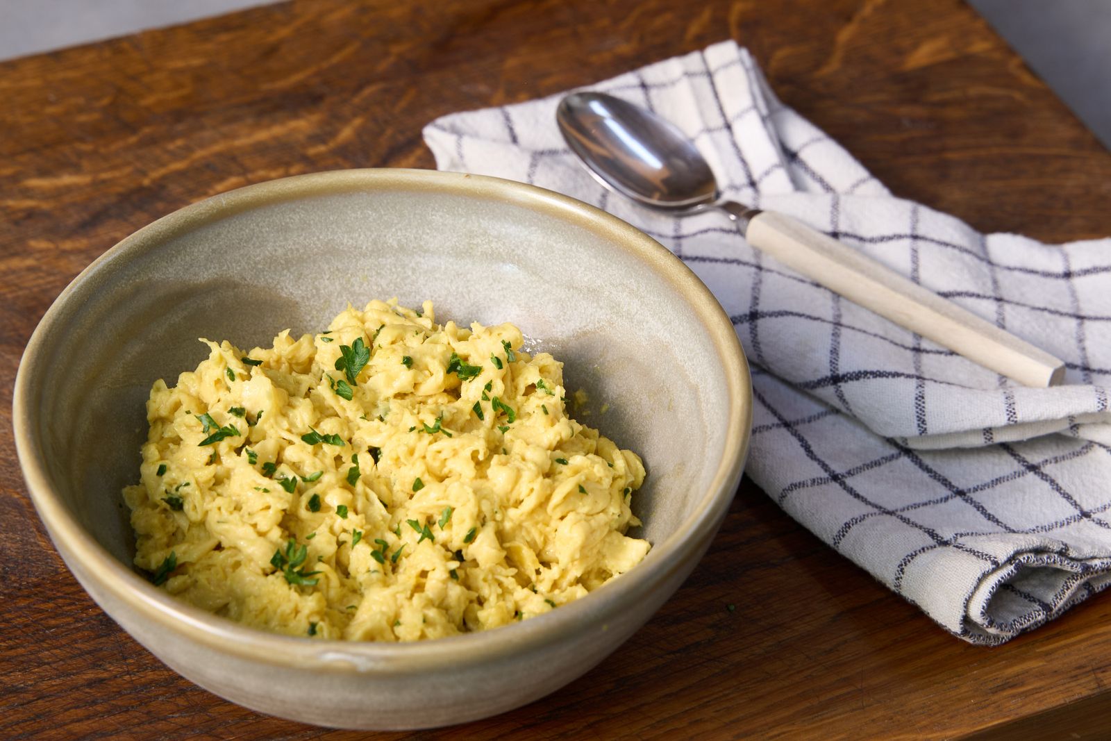 NoEgg Scramble with parsley in a ceramic bowl on a wooden board